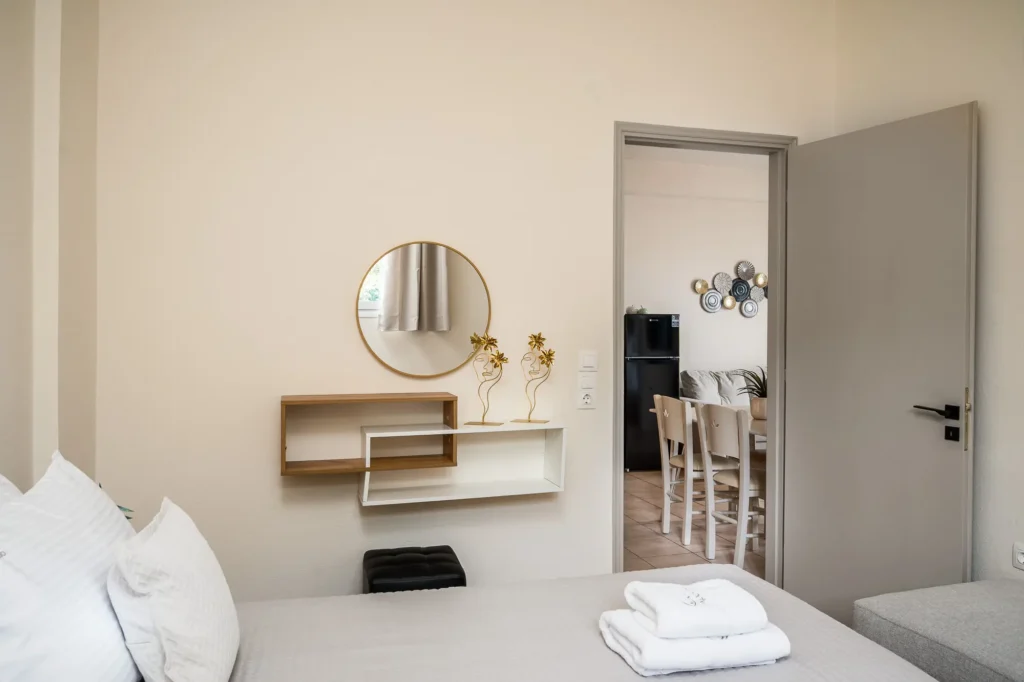 Minimal apartment vanity area with towels and mirror at Apovrado Stay