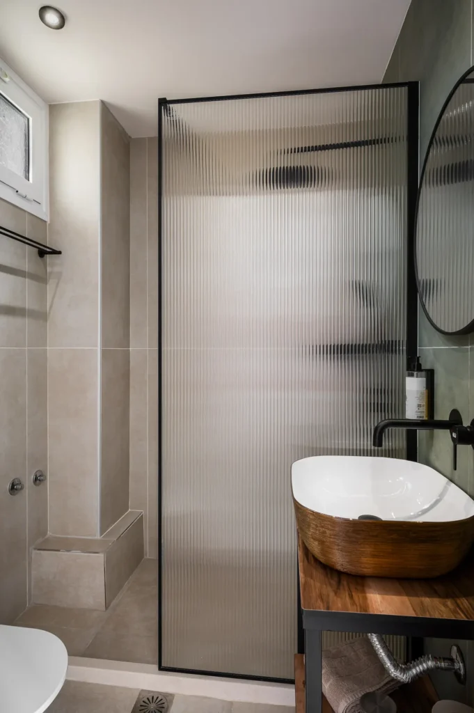 Modern bathroom shower with black fixtures at Apovrado Stay